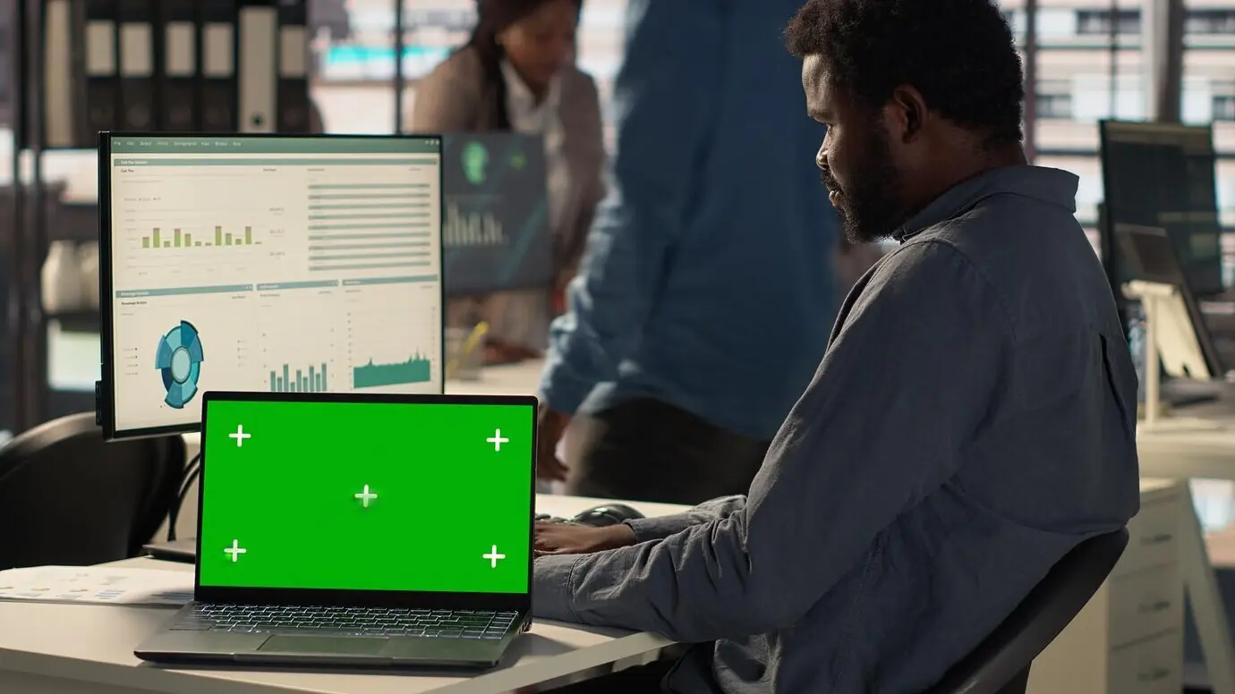Генеральный менеджер-мужчина смотрит на экран с макетом и решает задачи.