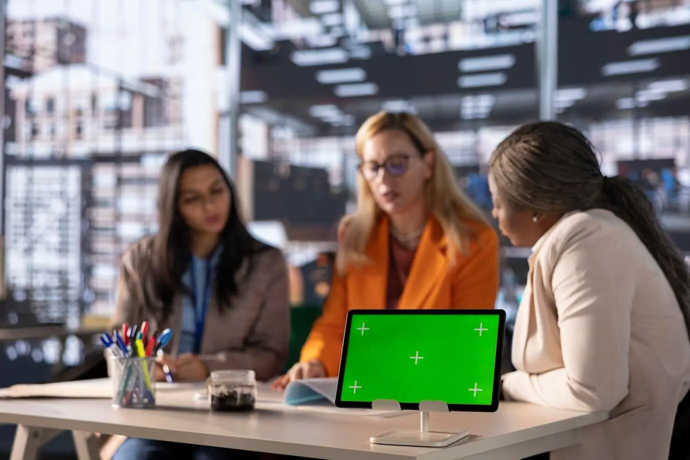 Разнообразная группа деловых женщин занимается стратегическим планированием в профессиональном офисе с зеленым экраном.